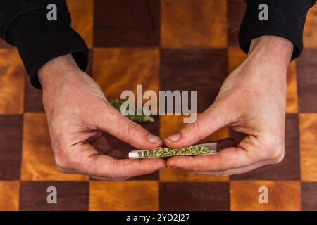 Rotolare a mano un giunto di cannabis da zero Foto Stock