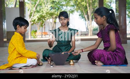 Una famiglia indù si riunisce intorno a un fuoco sacro per Yagya durante una festa. I rituali Havan e pooja includono offerte e mantra vedici Foto Stock