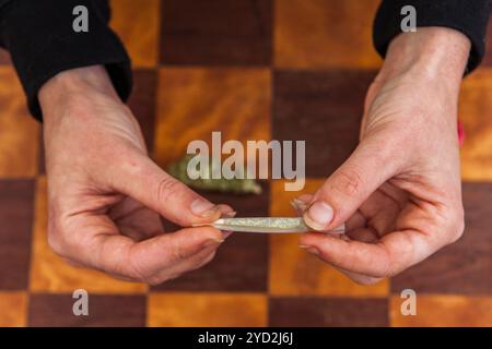 Rotolare a mano un giunto di cannabis da zero Foto Stock