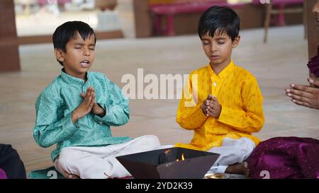 Una famiglia indiana tradizionale impegnata in un rituale sacro Yagya per armonizzare le energie all'interno della casa. La cerimonia del fuoco e' condotta per Vastu Shanti, io Foto Stock