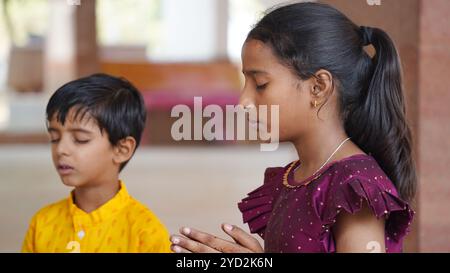 Una famiglia indù si riunisce intorno a un fuoco sacro per Yagya durante una festa. I rituali Havan e pooja includono offerte e mantra vedici Foto Stock