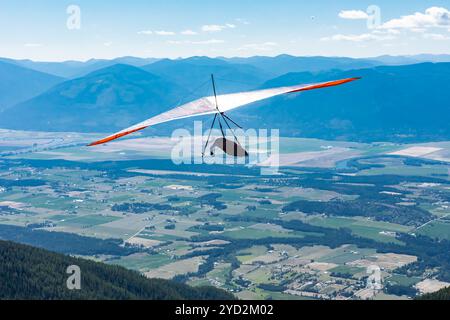 Il deltaplano si trova sopra la collina e la città. Deltaplano in azione. Delta deltaplano approfittare della bella giornata Foto Stock