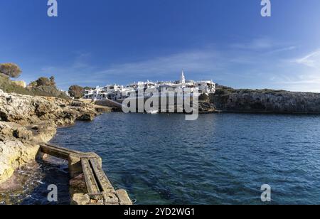 Binibeca Vell, Spagna, 24 gennaio 2024: Baia idilliaca e il villaggio imbiancato di Binibeca Vell a Minorca, Europa Foto Stock