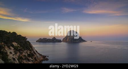 Una vista panoramica dell'isola di es Vedra e delle rocce al largo della costa di Ibiza all'alba Foto Stock