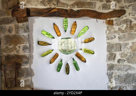 Una vista dettagliata di una vetrata colorata realizzata con bottiglie di vetro in una piccola rustica cabina di montagna Foto Stock