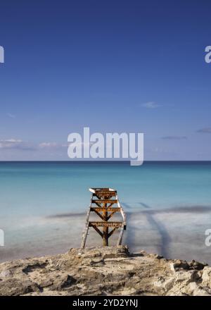 Un vecchio molo conduce alle acque turchesi della spiaggia di Ses Illetes nel nord di Formentera Foto Stock