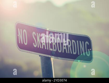 Foto in stile retrò di Un cartello senza skateboard al tramonto con lucernario Foto Stock