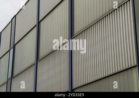 Edificio moderno con pannelli metallici e finestre di vetro che formano uno schema ripetuto Foto Stock