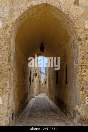 Mdina, Malta, 22 dicembre 2023: Porta che conduce in uno stretto vicolo nella città vecchia di Medina, Europa Foto Stock