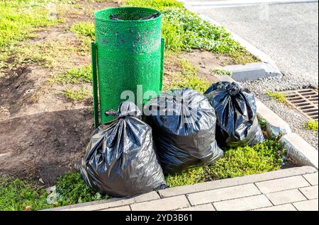 Contenitore di metallo per rifiuti e sacchetti di plastica per rifiuti Foto Stock