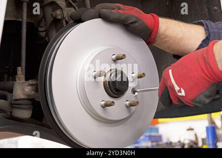Primo piano dell'installazione di un nuovo disco del freno in un'auto moderna Foto Stock