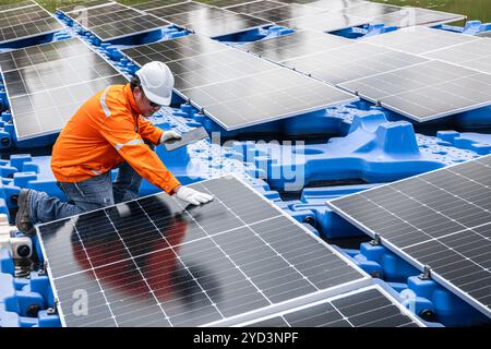 Pannello solare galleggiante di assistenza tecnico professionale. Manutenzione del lavoratore pulizia sostituzione del pannello solare. Sistema di pannelli fotovoltaici solari in Industry lak Foto Stock