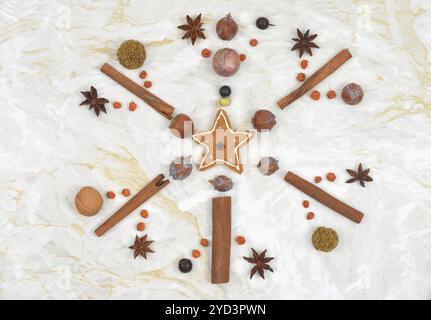 Connesso con il Natale: Forma a fiocco di neve fatta di spezie, noci e semi su tavolo in marmo in cucina. Vista dall'alto. Foto Stock