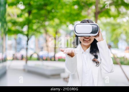 Donne d'affari moderne che utilizzano la tecnologia di realtà visiva VR. Persone che guardano il dispositivo di gadget in vetro all'aperto, parco verde all'aperto. Foto Stock