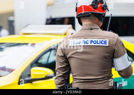 L'agente di polizia stradale thailandese che lavora su strade trafficate della metropolitana di Bangkok risolve problemi di ingorghi e sicurezza pubblica Foto Stock