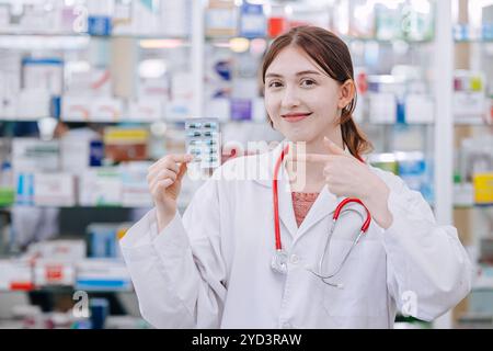 Farmacista felice sorridere in punto di mano farmacia promuovere mangiare la vitamina della medicina per la salute, il problema di salute dei farmaci. Foto Stock