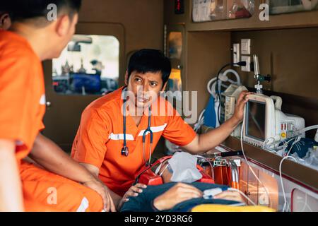 Paramedici che si occupano di un paziente all'interno di un'ambulanza, fornendo cure mediche di emergenza con attenzione e urgenza. Foto Stock