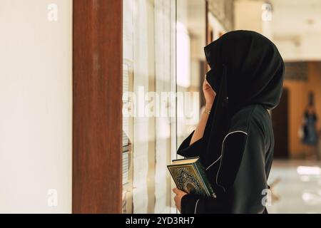 Studente musulmano all'università che indossa niqab nero. Donna araba chador nera. Foto Stock