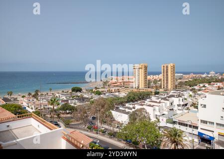 Zona vivace con palme, sentieri ben curati e hotel moderni lungo la strada, popolare destinazione turistica sull'isola, Las Americas Foto Stock