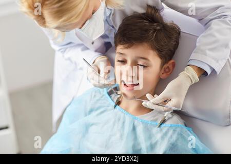 In una clinica odontoiatrica, un medico esamina i denti di un ragazzo, da vicino Foto Stock