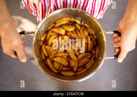 Le mani dell'uomo tengono in mano una pentola d'argento con ripieno di torta di mele fatta in casa Foto Stock