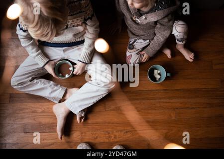 I fratelli e sorelle potranno gustare Una tazza di cioccolata calda al piano di casa Foto Stock