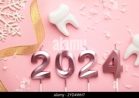 Figura 2024 e dente con decorazione natalizia su sfondo rosa. Vista dall'alto Foto Stock
