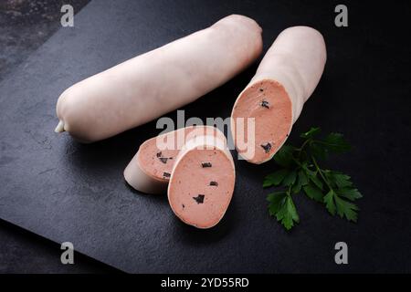 Salsiccia di vitello tradizionale tedesca con pane contadino offerto in primo piano su un piatto nero con spazio di testo Foto Stock