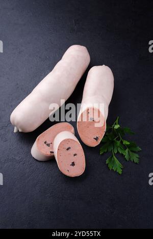 Salsiccia di vitello tradizionale tedesca con pane contadino offerto in primo piano su un piatto nero con spazio di testo Foto Stock