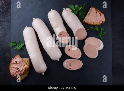 Salsiccia di vitello tradizionale tedesca con pane contadino offerto come vista dall'alto su una lavagna nera con spazio di testo Foto Stock