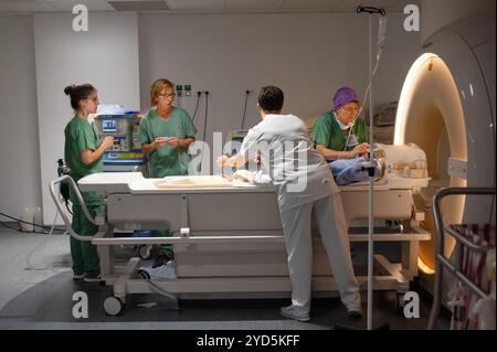 Un team medico che prepara un paziente per una scansione di risonanza magnetica (MRI). Foto Stock