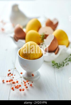 Composizione pasquale con uova gialle e fiori. Uova colorate naturali e fiori primaverili composizione rustica. Primo piano. Hap Foto Stock