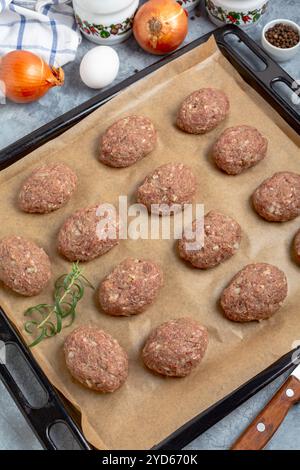 Cotolette di carne macinata cruda prima della cottura. Foto Stock