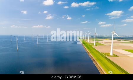 Un'incantevole vista dall'alto cattura la danza graziosa delle turbine a vento in un vasto parco eolico oceanico, situato nei Paesi Bassi Foto Stock