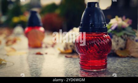 Festa di tutte le anime. Una candela accesa sulla tomba. Sfondo con cimitero. Periodo autunnale e vacanze. Soulstice - ricordo del de Foto Stock