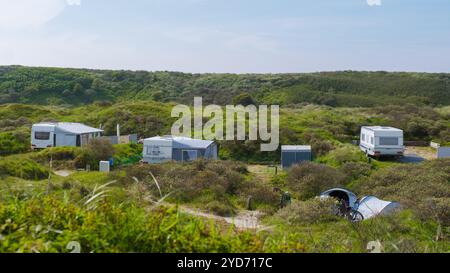 Un gruppo di camper moderni parcheggiati in armonia su una lussureggiante collina verde a Texel, Paesi Bassi Foto Stock