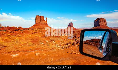 Lo specchio dell'auto riflette il paesaggio panoramico. Il famoso rock Mitten. STATI UNITI. Riserva indiana Navajo. Monument Valley Foto Stock