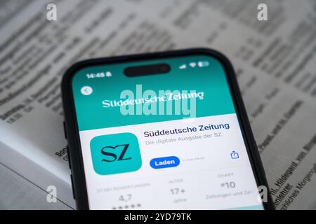 Baviera, Germania - 25 ottobre 2024: IPhone con l'app Süddeutsche Zeitung SZ nell'Appstore su un quotidiano. Immagine simbolica interruzione delle edizioni cartacee locali e chiusura degli uffici editoriali locali *** iPhone mit der App Süddeutsche Zeitung SZ im Appstore auf einer Zeitung. Symbolbild Einstein der lokalen Printausgaben und schließung der Lokalredaktionen Foto Stock
