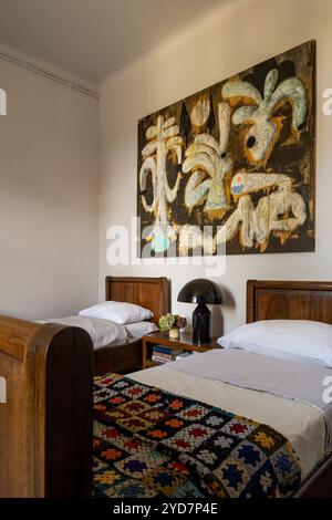 Opere d'arte astratte sopra i letti gemelli con coperte a crochet nella lussuosa villa nel sud della Francia. Foto Stock