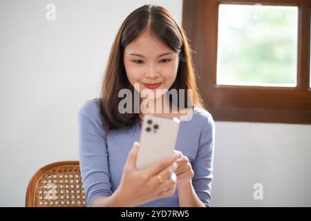 Bella donna asiatica che parla su smartphone avere conversazione chat virtuale online videochiamata con gli amici. Vlog lifestyle girl Foto Stock