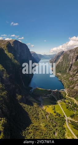 Lysebotn, Lysefjorden, Norvegia una vista aerea di un tranquillo fiordo norvegese circondato da lussureggianti montagne verdi su un luminoso soleggiato da Foto Stock