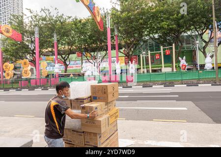 Uomo cinese che trasporta scatole di cartone a Chinatown Singapore Foto Stock