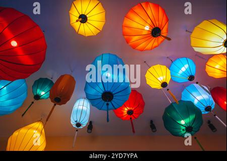 Tradizionali lanterne cinesi sospese in seta multicolore dal soffitto di un caffè asiatico per la decorazione degli interni Foto Stock