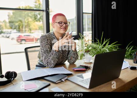 La donna calva con i capelli rosa sorride mentre si impegna nel suo lavoro, circondato da forniture per ufficio. Foto Stock