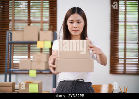 Affari da Casa donna asiatica che prepara la scatola di consegna del pacchetto spedizione per lo shopping online. giovane titolare di una piccola impresa Foto Stock