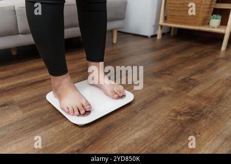 Dieta grassa e piedini graduati posizionati su bilance elettroniche per il controllo del peso. Strumento di misurazione in chilogrammi per il controllo della dieta. Foto Stock