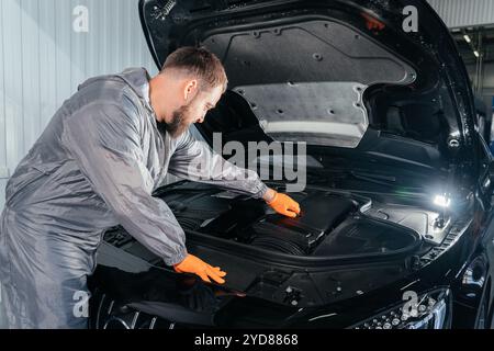 Auto Mechanic controllo auto con cofano aperto in officina auto riparazione Foto Stock