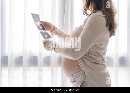 Donna asiatica incinta che tiene in mano Â ecografia bambino risultato immagine dal medico. Felice idea di assistenza sanitaria mamma Foto Stock