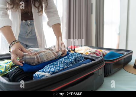 Donna che trasporta la valigia sul letto per una nuova lista di viaggio per pianificare il viaggio preparando la vacanza Prenota ora viaggio trasporto Foto Stock