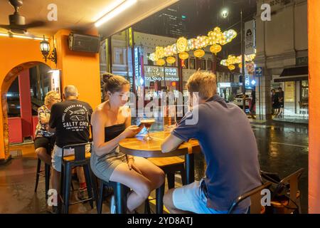 Singapore Chinatown, bar all'aperto situato su Mosque Street, coppia caucasica che beve birra Foto Stock